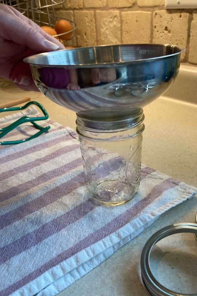 place a canning funnel into the mouth of the jar