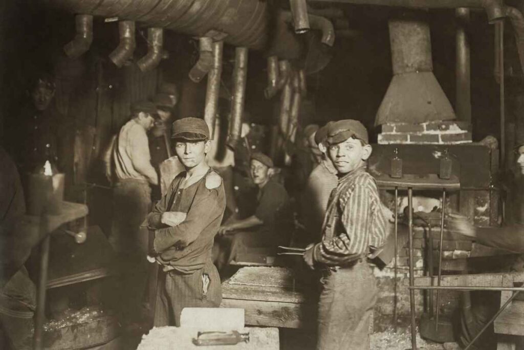 Black and white photo of young laborers in a factory during the Industrial Revolution