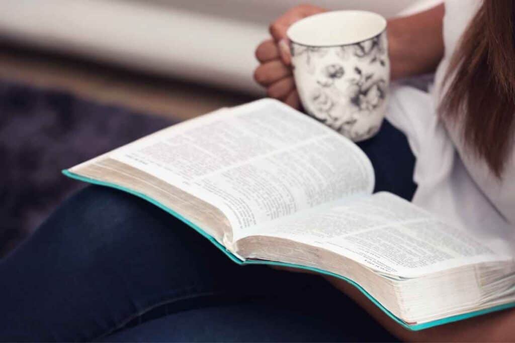 woman reading Bible with cup of tea