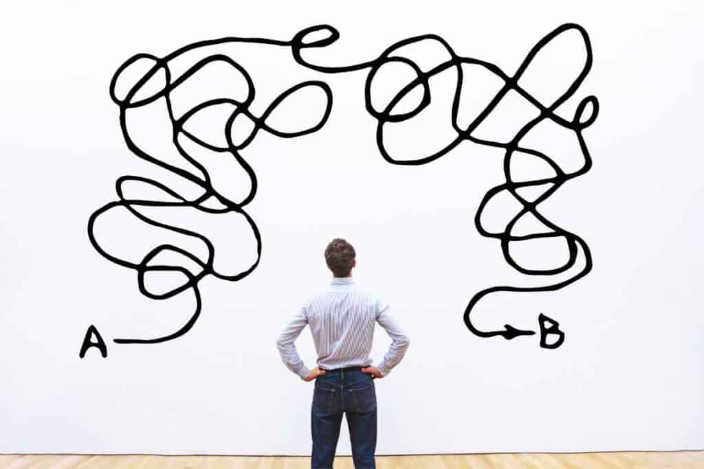 man standing in front of wall with squiggly lines from point a to point b (overcomplicated)