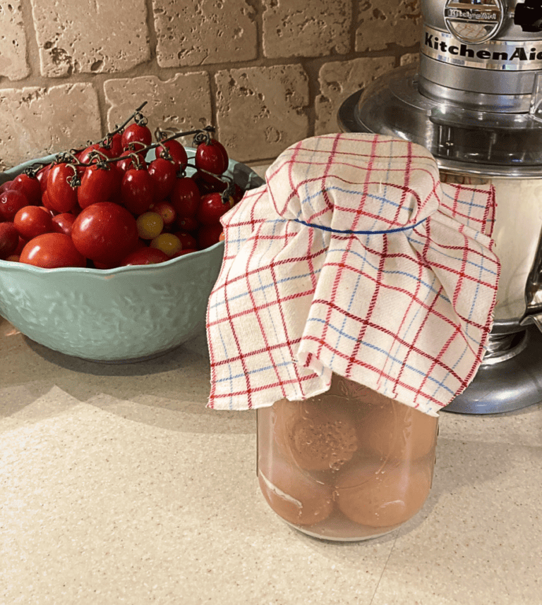 Water-glassed eggs in canning jar on counter with cotton cover.
